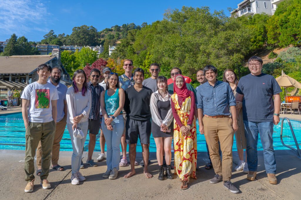 The Karthik Shekhar lab members stand in front of a pool.