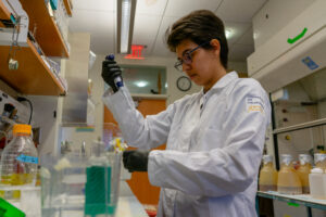 Martin lab researcher working with pipette.