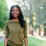 Leah Guthrie standing outside in front of trees.