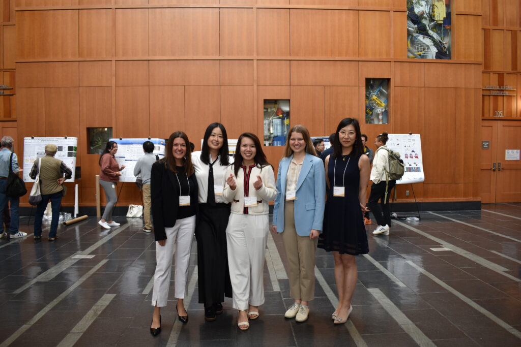 A panelist and four conference organizers standing in Stanley Hall.