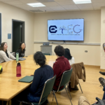 A group of researchers sits around a table and looks at logos for CTEG.