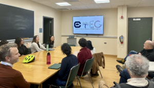 A group of researchers sits around a table and looks at logos for CTEG.